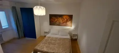 a bedroom with a bed and a painting on the wall at Domus Appio Latino - Parco Appia Antica in Rome