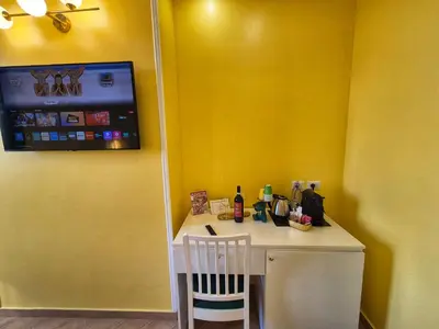 a yellow room with a small table with a chair at Residenze Serventi Longhi in Rome