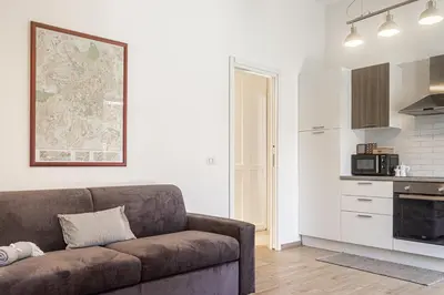 a living room with a couch and a kitchen at [Flaminio * * * * *] - Loft con Giardino in Rome