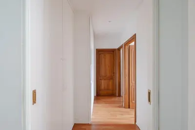 an empty hallway with white walls and wooden doors at Cesarina Home in Rome