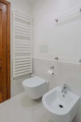 a white bathroom with a toilet and a sink at Cesarina Home in Rome