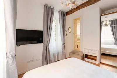 a white bedroom with a bed and a window at In the shadow of the Colosseum in Rome