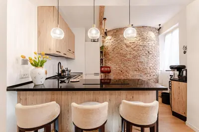 a kitchen with a bar with stools and a brick wall at In the shadow of the Colosseum in Rome