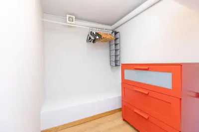 a room with a red dresser next to a wall at Colosseum bright two Bedroom Apartment in Rome