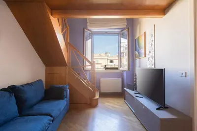 a living room with a blue couch and a television at Colosseum bright two Bedroom Apartment in Rome