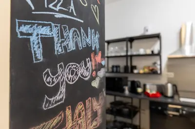 a blackboard with graffiti on it in a kitchen at Domus Christina in Rome