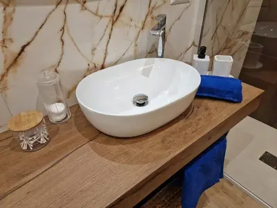 a white sink on a wooden counter in a bathroom at Vacanze Romane Apartments - Vatican City in Rome