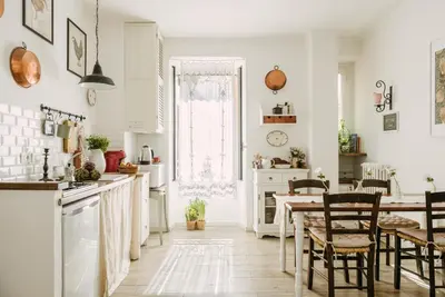 a kitchen with white walls and a table and chairs at Casa Riva 1920 in Rome