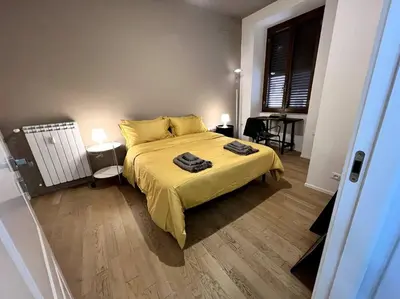 a bedroom with a bed with a yellow bedspread at La Casa del giornalista - ItalyHolidayHouse in Rome