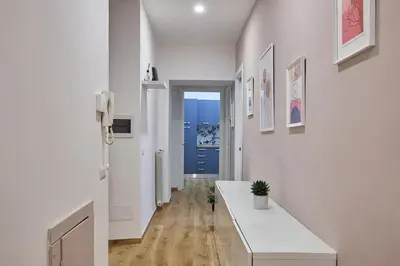 a hallway with white walls and a long white table at Casa Pallini Luxury Apartment in Rome