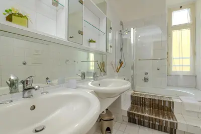a white bathroom with a sink and a tub at Suite Apartment Prati in Rome