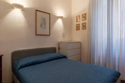 a bedroom with a bed with a blue blanket at GuestHost - A due passi da Santa Maria Maggiore Apartment in Rome