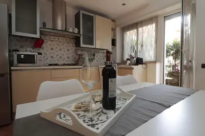 a bottle of wine sitting on a table with a glass at Luminoso e accogliente appartamento con giardino - Battistini in Rome