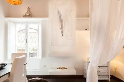 a dining room with a window and a table and a desk at Endless beauty - Charming attic in the heart of Rome in Rome