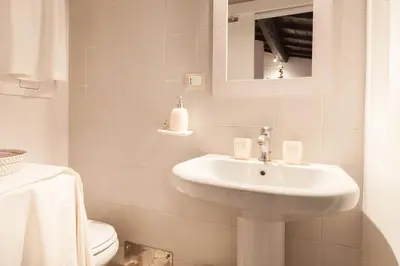 a white bathroom with a sink and a toilet at Endless beauty - Charming attic in the heart of Rome in Rome