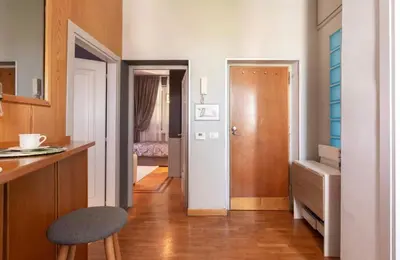 a kitchen with a table and a stool in a room at Vatican Home 51 in Rome