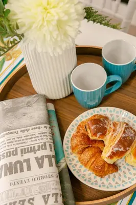 a table with a plate of croissants and a book at Parisi apt in Rome