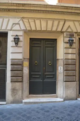 a black door on a building with two lights at Leoncino 36 Apartments in Rome in Rome