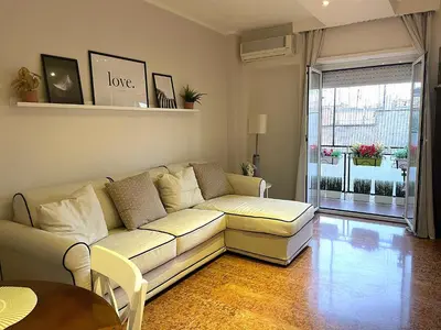 a living room with a white couch and a table at La Casa Libre Metro A Colli Albani 350 m in Rome