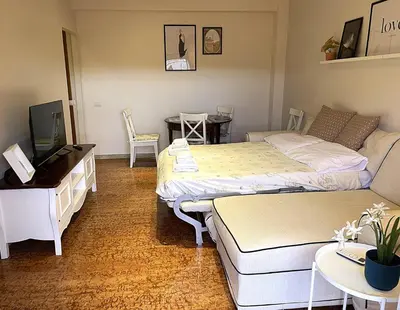 a room with two beds and a couch and a table at La Casa Libre Metro A Colli Albani 350 m in Rome