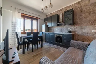 a kitchen and dining room with a table and chairs at GuestHost - Valle Aurelia Elegant Apartment in Rome