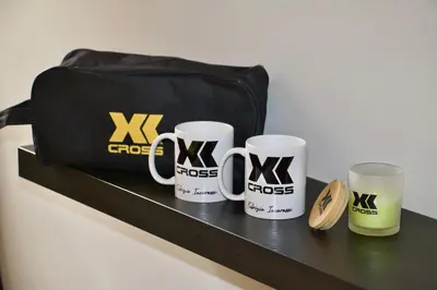 three coffee mugs and a bag on a shelf at XCross Suites Roma in Rome