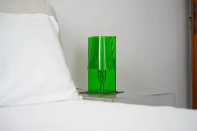a green vase sitting on top of a bed at Art House Vaticano Apartment in Rome