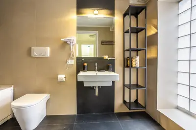 a bathroom with a sink and a toilet and a mirror at Trastevere Double A LOFT in Rome