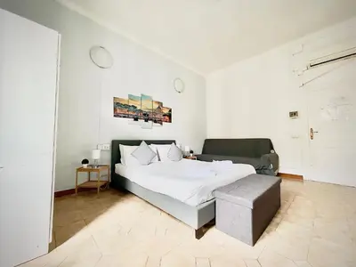 a white bedroom with a bed and a couch at Rome Room Vatican in Rome