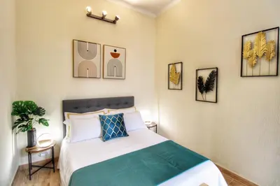 a bedroom with a bed and some pictures on the wall at Lovely 2 Bedroom apartment by YourHost in Rome