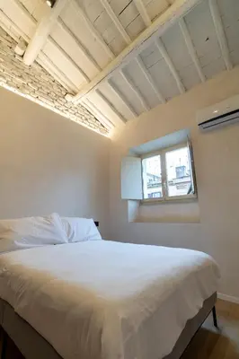 a bedroom with a white bed and a window at Cunabu Urbano in Rome