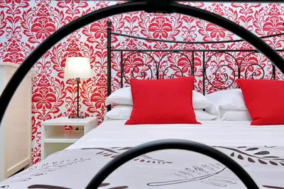 a bedroom with a red and white bed with red pillows at Cozy Tritone - My Extra Home in Rome