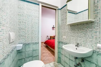 a bathroom with a sink and a toilet and a mirror at Prati House in Rome