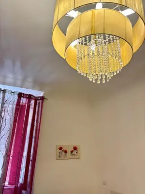 a large yellow chandelier hanging from a ceiling at Prati House in Rome