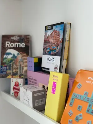 a shelf with books and other items on it at Olimpia Villa Pamphili - Centro Storico di Roma - Gianicolo Trastevere San Pietro in Rome