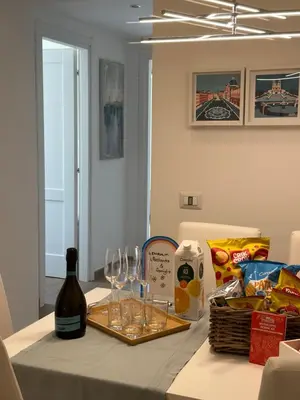 a table with a bottle of wine and glasses on it at Olimpia Villa Pamphili - Centro Storico di Roma - Gianicolo Trastevere San Pietro in Rome