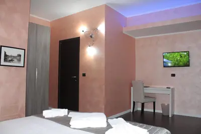 a bedroom with a desk and a tv on the wall at B&B Roma in Rome