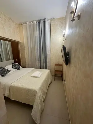 a hotel room with a bed and a television at Termini Sunlight House in Rome
