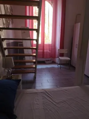 a bedroom with a bed and a window and a chair at Casa Manzoni in Rome
