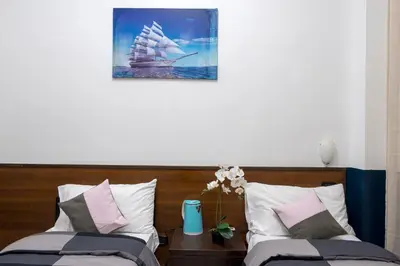 a bedroom with two beds with a pirate ship picture on the wall at STELLA GUEST HOUSE O AFFITTACAMERE in Rome