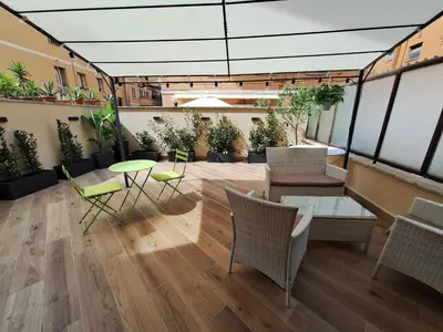 a room with chairs and tables and potted plants at Peaceful 2 Bedrooms with patio, near Metro A in Rome