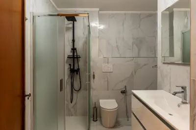 a bathroom with a shower and a toilet and a sink at GuestHost - Rione Sallustiano Elegant Apartment in Rome