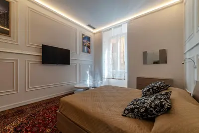 a bedroom with a bed and a flat screen tv at GuestHost - Rione Sallustiano Elegant Apartment in Rome