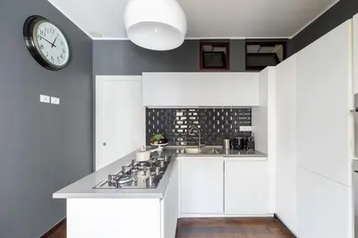a kitchen with a sink and a clock on the wall at iFlat Contemporary Elegance in the heart of Rome in Rome