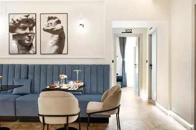 a living room with a blue couch and a table at Adriana Boutique Guest House in Rome
