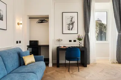 a living room with a blue couch and a table at Adriana Boutique Guest House in Rome