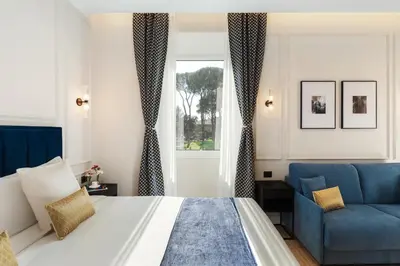 a bedroom with a bed and a blue chair at Adriana Boutique Guest House in Rome