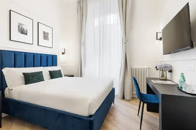 a bedroom with a bed and a desk with a computer at Belli Boutique Guest House in Rome