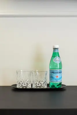a bottle of soda and two glasses on a tray at Belli Boutique Guest House in Rome