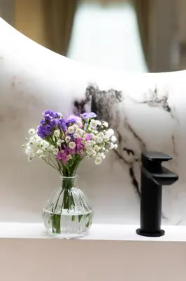 a glass vase with purple and white flowers on a shelf at Sistina Boutique Guest House in Rome